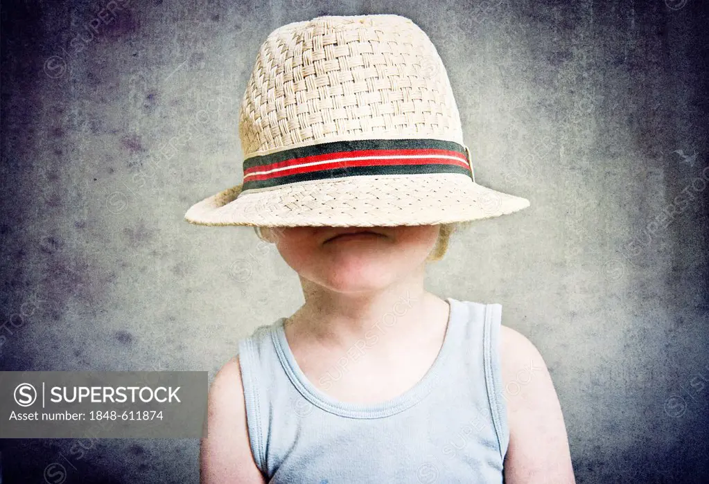 Little boy with large straw hat pulled over his head