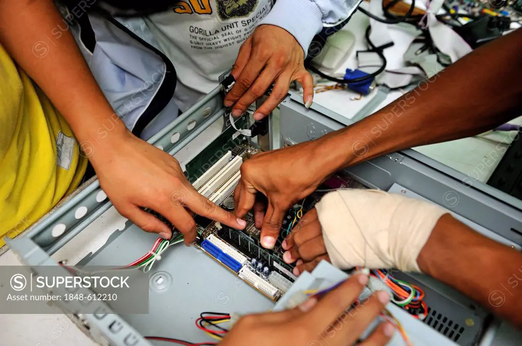 Young people assembling a computer, detailed view