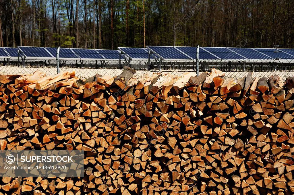 Stacked firewood, large photovoltaic power plant on a former waste disposal site at the back, completed in April 2012, Betzenstein, Upper Franconia, B...