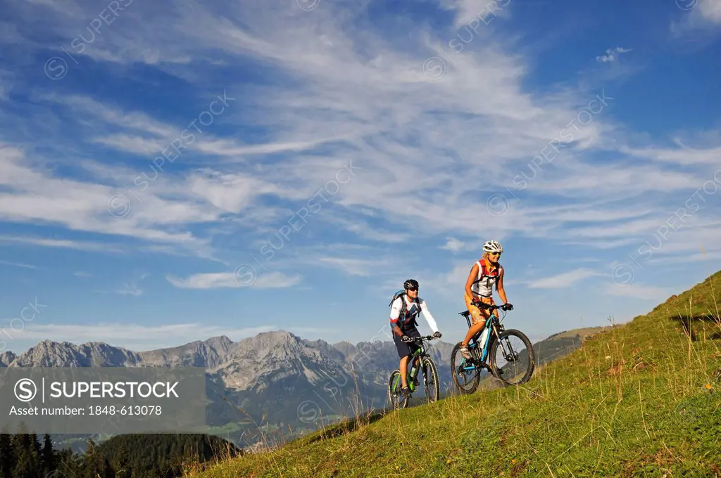 Mountain bikers at Kraftalm alp, Wilder Kaiser massif at back, Mt Hohe Salve, Kitzbuehel Alps, Tyrol, Austria, Europe