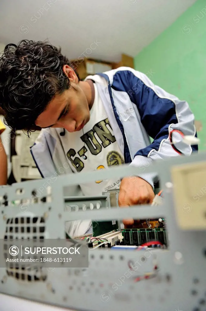 Teenager, 18 years old, a former hired killer and member of a gang of youths, Mara, learning how to build a working computer from used parts at the Pa...