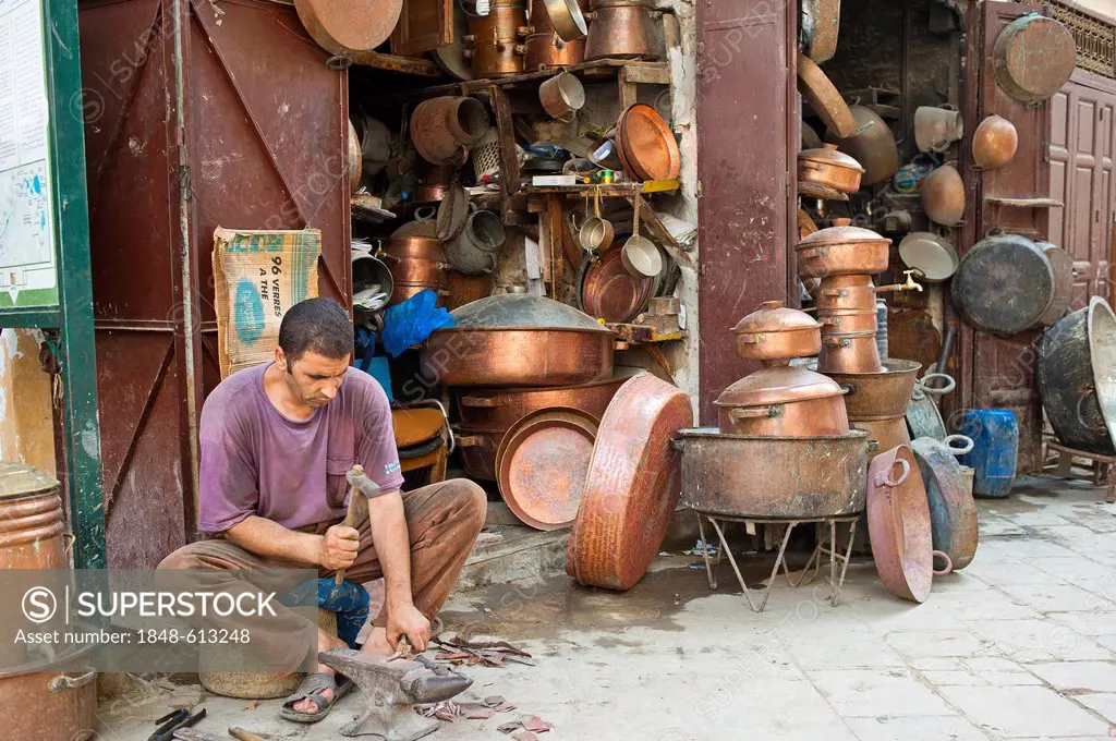 A coppersmith at work outside his shop in the coppersmiths' alley, souk, bazaar, Medina, Fes, Morocco, Africa