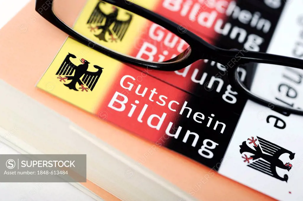 Glasses lying on vouchers, Bildungsgutschein coupons, lettering Gutschein Bildung, German for education voucher, symbolic image