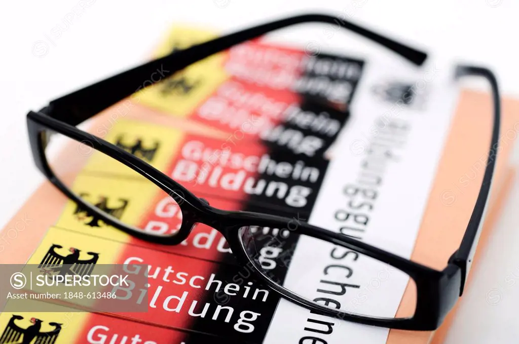 Glasses lying on vouchers, Bildungsgutschein coupons, lettering Gutschein Bildung, German for education voucher, symbolic image