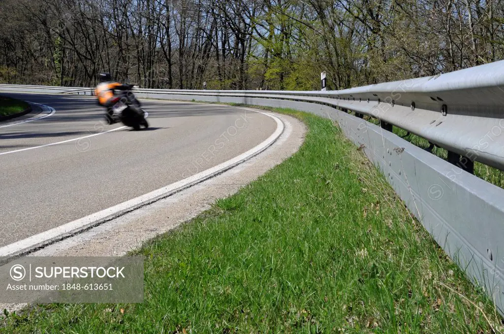 Motorcyclist in a curve on a country road with guard rail for protection, Eifel, Germany, Europe