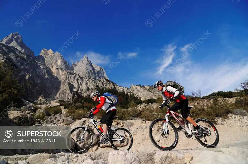 Mountain bikers cycling in the Klausbachtal valley, Ramsau region, Muehlsturzhoerner mountains at the back, district of Berchtesgadener Land, Upper Ba...
