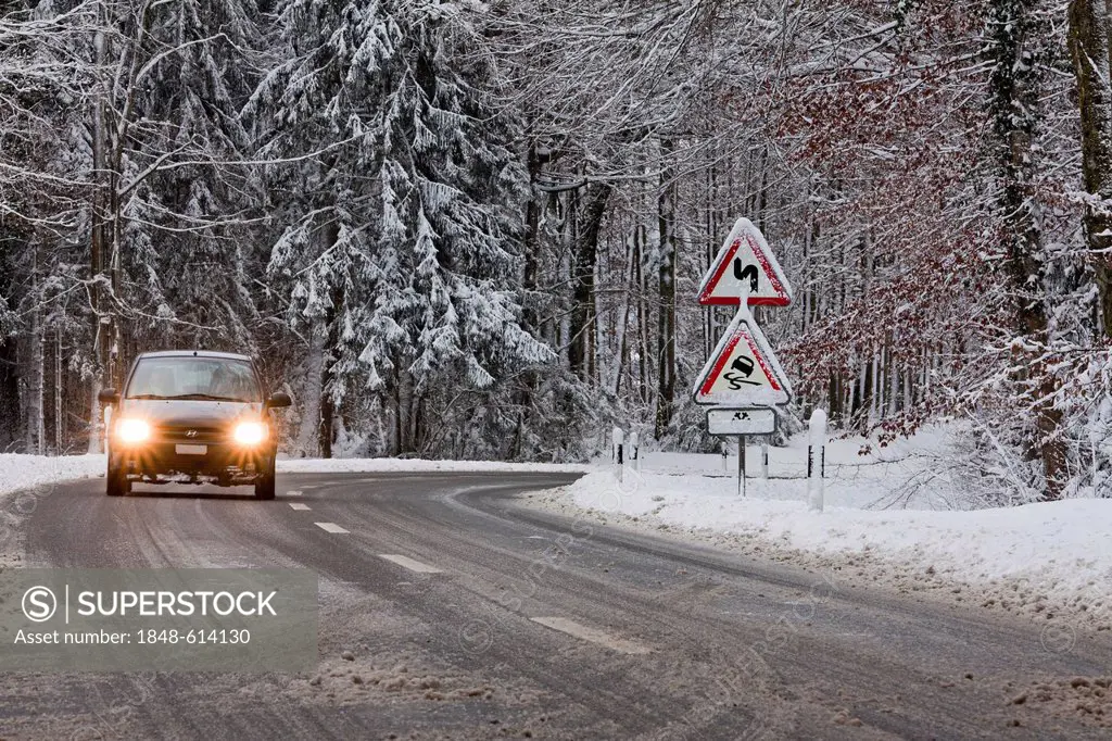 Sign, curves, danger of skidding, car on a road in winter, Baden-Wuerttemberg, Germany, Europe