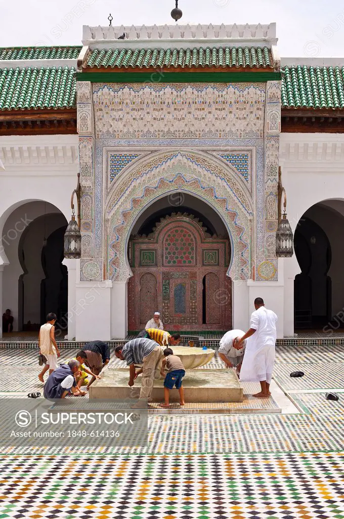 Muslim men cleaning their feet before prayer in the courtyard of Kairouan mosque and university, Medina, Fes, Morocco, Africa