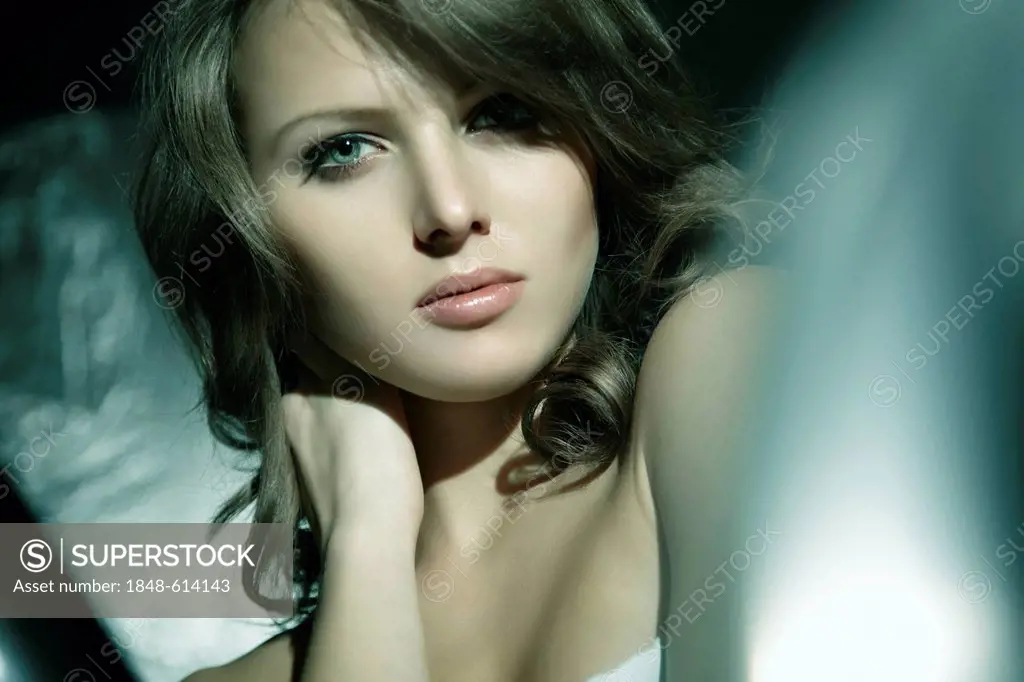 Portrait of a young woman surrounded by light and shadow