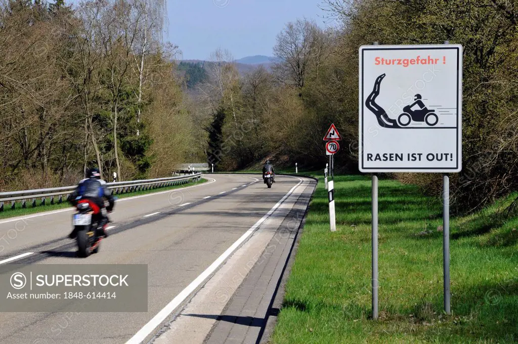 Motorcyclist on a country road with a warning sign, Sturzgefahr - Rasen ist out, German for dangerous curves - no speeding, Eifel, Germany, Europe