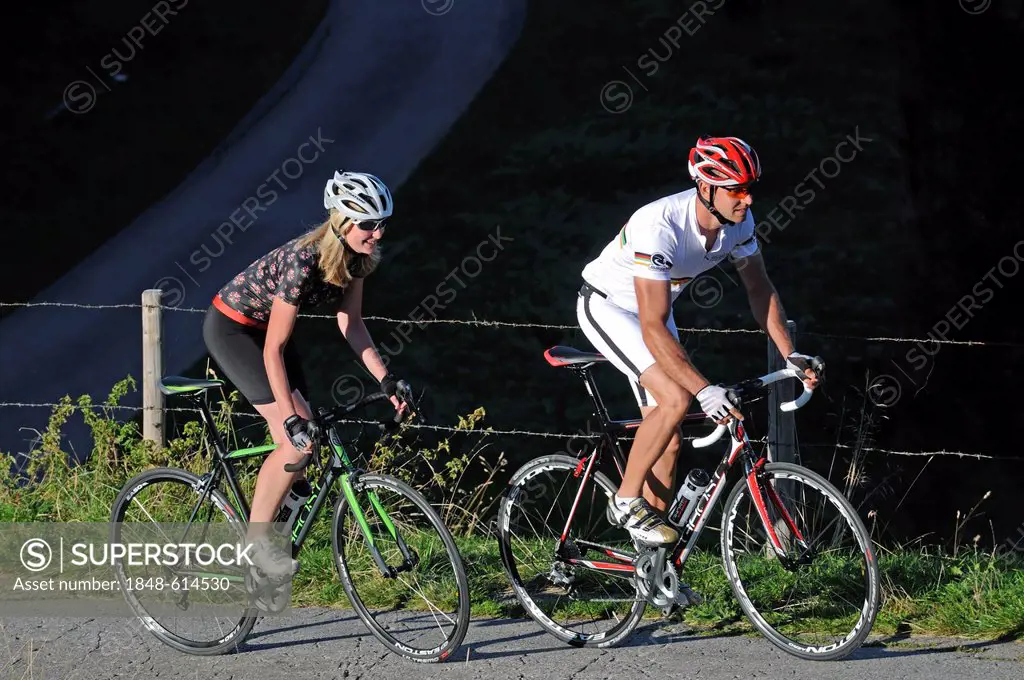 Couple riding racing bikes, Kraftalm alp, Mt Hohe Salve, Kitzbuehel Alps, Tyrol, Austria, Europe