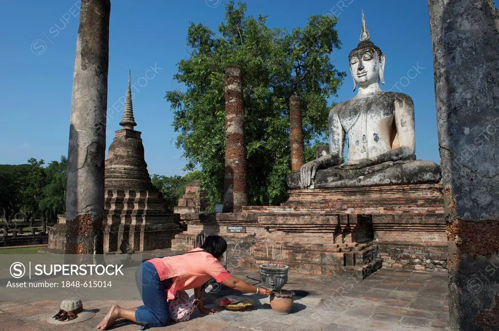 Woman lighting joss sticks, Buddha statue, Wat Mahathat, Sukhothai Historical Park, Sukhothai, Thailand, Asia