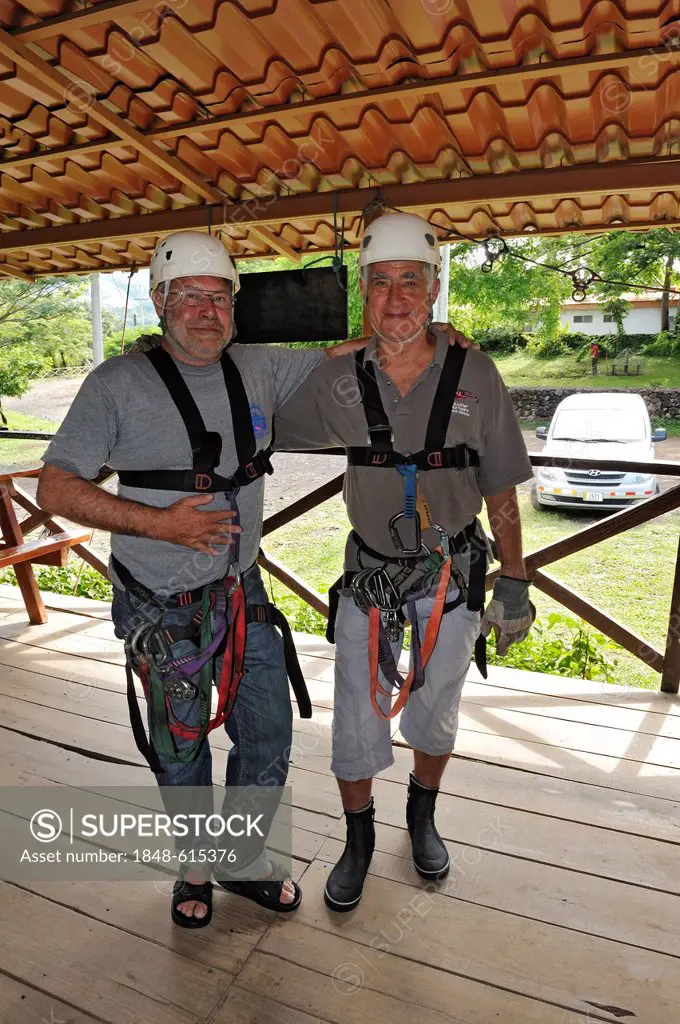 Two tourists, senior citizens, equipped for a canopy rope tour on the Hacienda Guachipelin near Liberia, Guanacaste Province, Costa Rica, Central Amer...