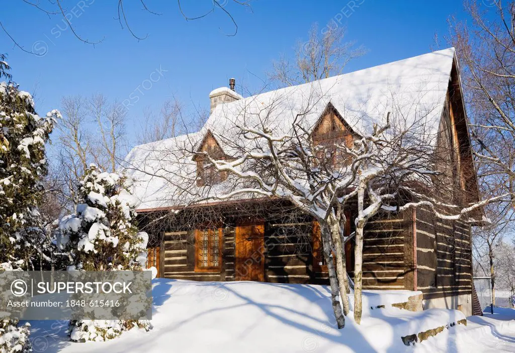 Old reconstructed Canadiana cottage-style residential log home, 1975, in winter, Quebec, Canada. This image is property released for book, calendar, m...