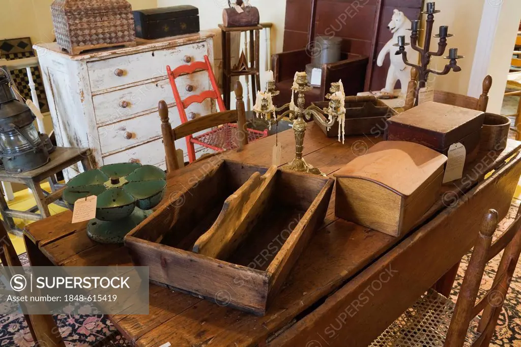 Antique wooden dining table with decorative objects inside an old residential home and antique store, Lanaudiere, Quebec, Canada. This image is proper...