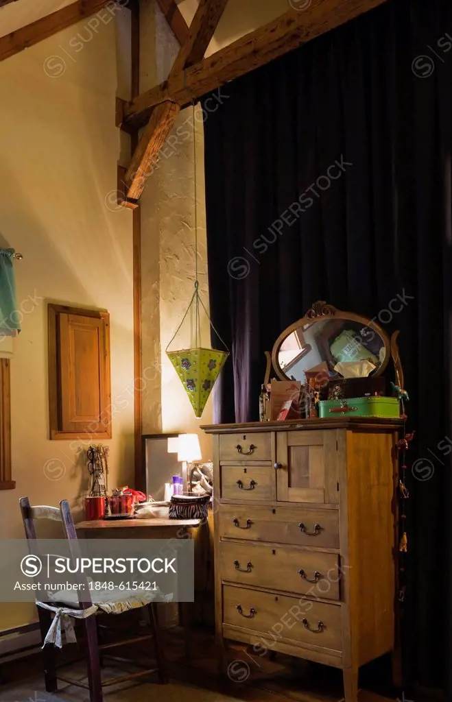 Antique chair, desk, dresser and furnishings in the upstairs bedroom of an old Canadiana cottage-style residential log home, circa 1825, Quebec, Canad...