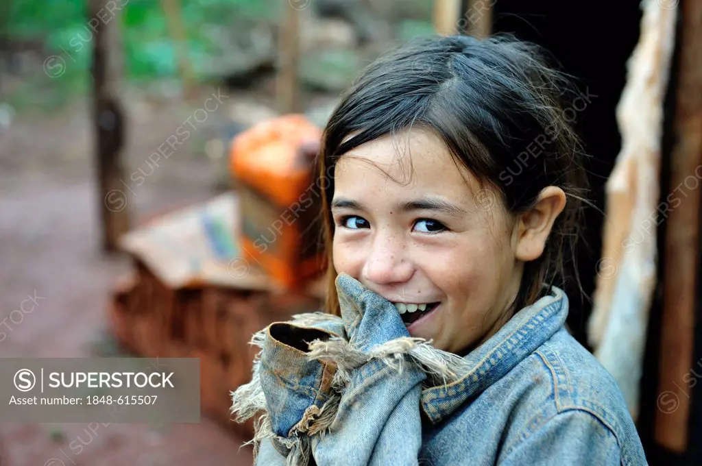 Portrait of a cheeky smiling girl, whose parents were forced off their land alongside dozens of other smallholders and their families by investors and...