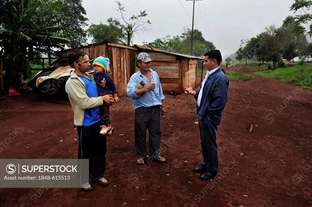 Human rights activists talking to smallholders who live in makeshift huts by the roadside, the farmers were forced off their land by investors, land g...