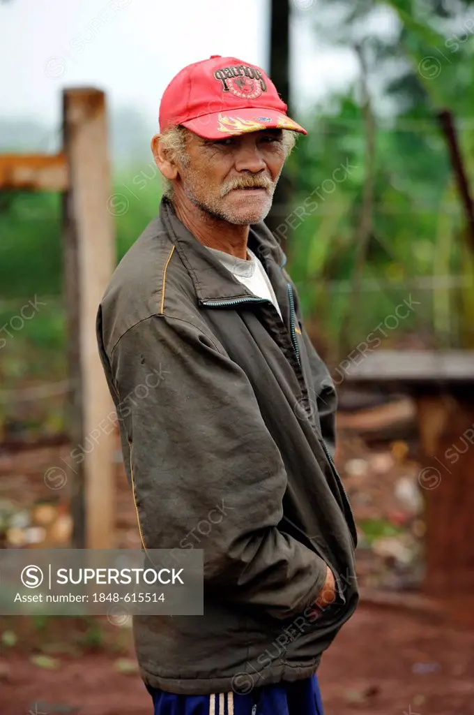Old farmer, who was evicted from his land alongside dozens of other smallholders and their families and now lives in a makeshift hut by the roadside, ...