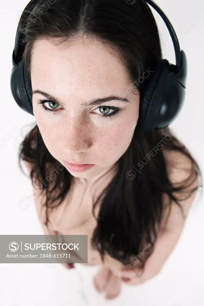 Young woman, naked, wearing headphones, bird's-eye view
