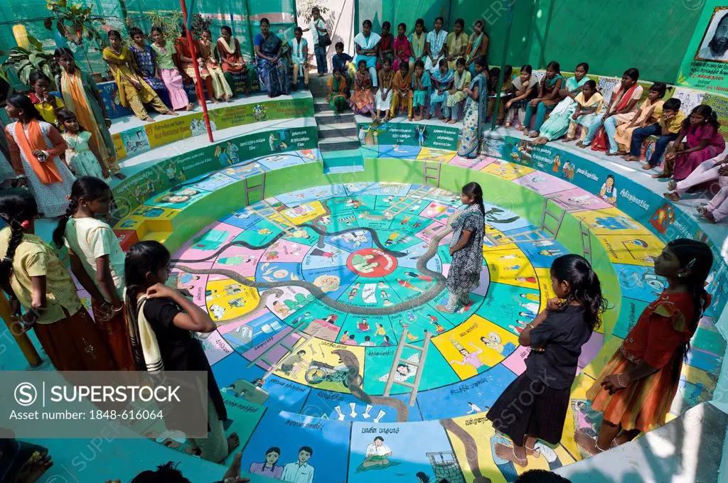 Indian girls playing Snakes and Ladders, Indian Moksha Patamu, an education game against child labour, Kutties Rajiyam, Kids' World, centre for childr...