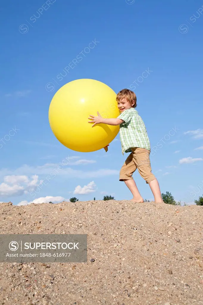 Little boy playing with a big balloon
