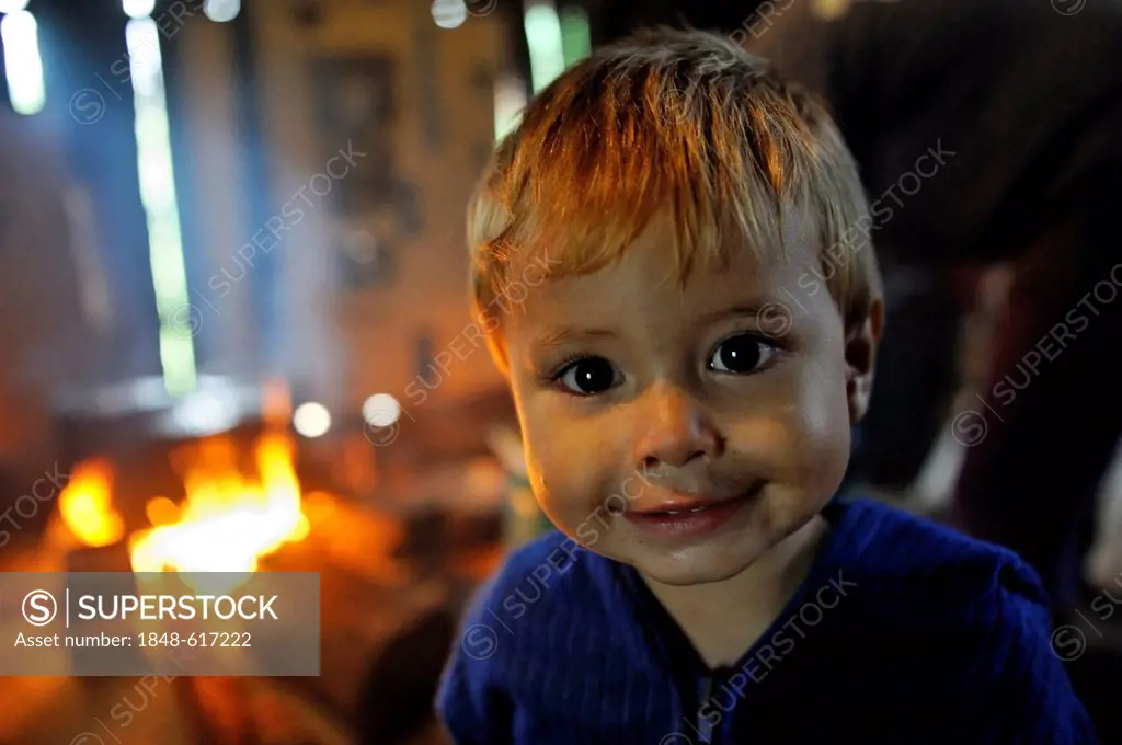 Boy in front of an open fire in a traditional kitchen, portrait, Comunidad Martillo, Caaguazu, Paraguay, South America
