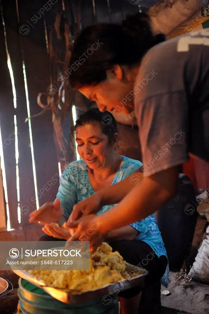 Women preparing the traditional dish Bory Bory in a simple kitchen on an open fire, soup with corn dumplings, Comunidad Martillo, Caaguazu, Paraguay, ...