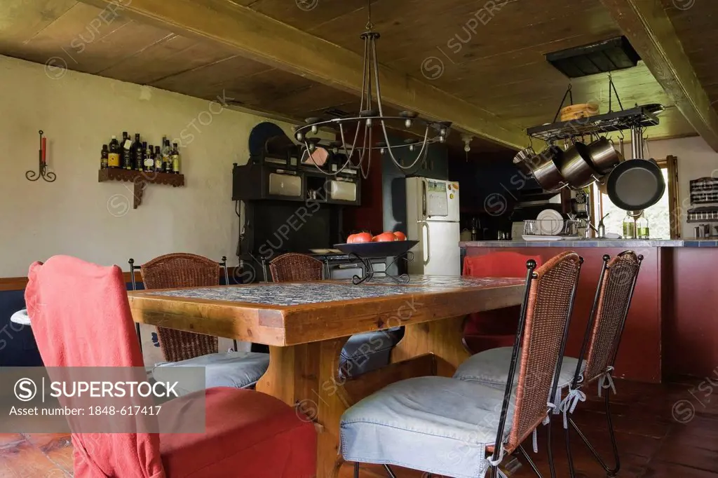 Old wooden table and chairs in the dining room of an old Canadiana cottage-style residential log home, circa 1840, Quebec, Canada. This image is prope...