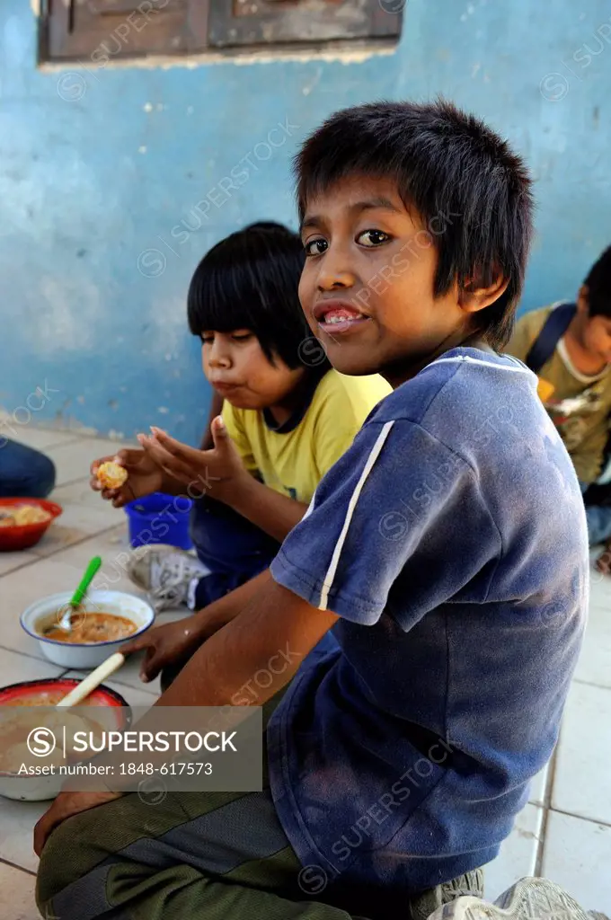 Boys eating lunch that was provided at the village school, village of the indigenous Wichi people, Comunidad Tres Pocos, Formosa province, Argentina, ...