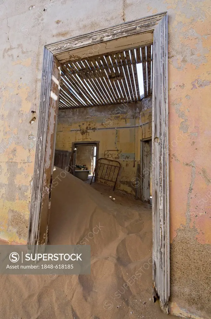 Desert sand and a door in a ruined house, abandoned diamond mine, Kolmanskop, Namibia, Africa