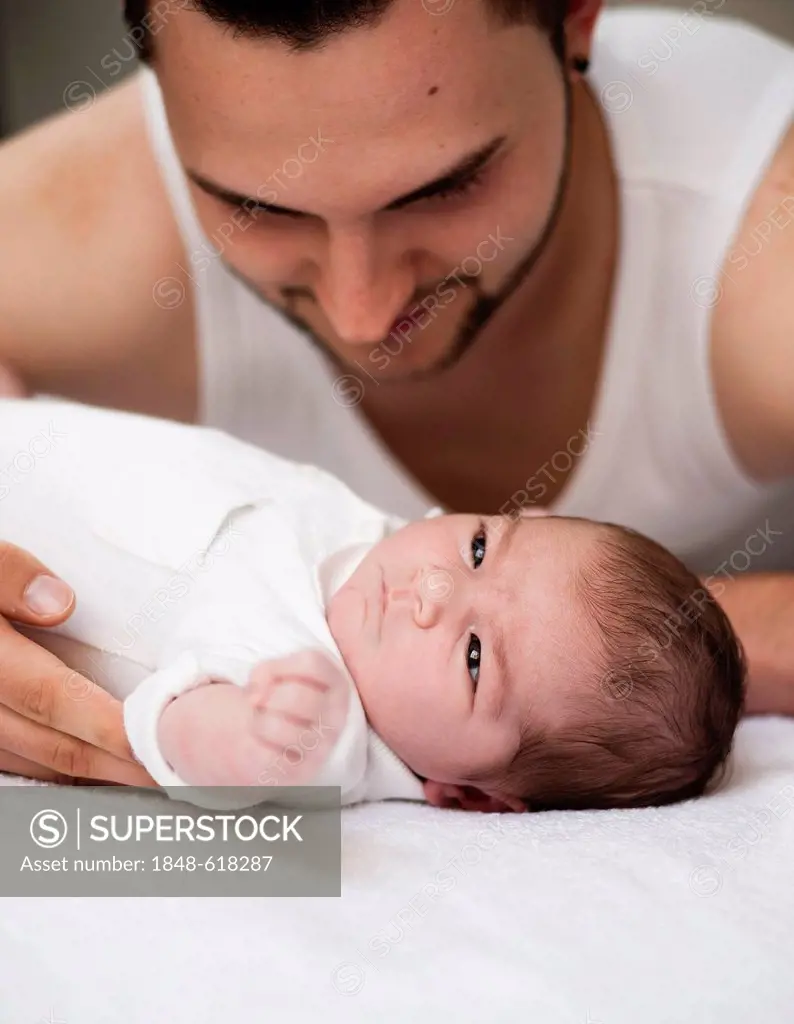 Father leaning lovingly over his newborn baby