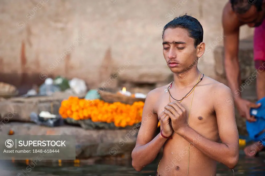 Young Hindu man with closed eyes during a morning prayer, the Ganges, Varanasi, Benares or Kashi, Uttar Pradesh, India, Asia