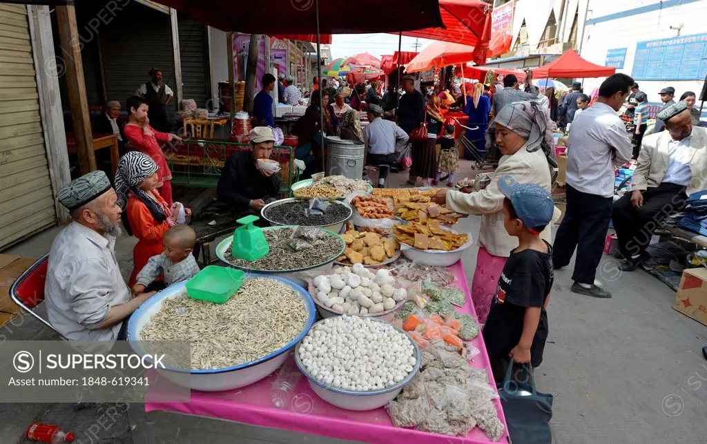 Sunday market, market stall of an Uyghur family selling sunflower seeds, dried fruit and nuts, Muslim bazaar, Uighur, Kashgar, Xinjiang, China, Asia