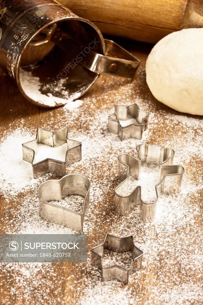 Flour with cookie cutters, dough and a rolling pin
