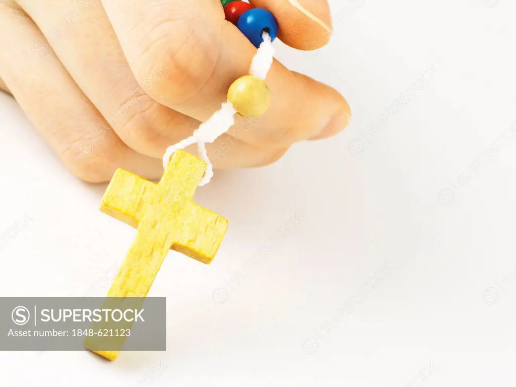 Female hand holding the cross of a rosary