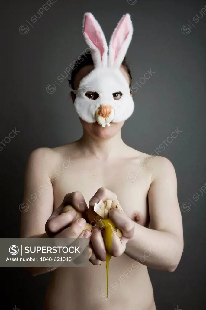 Woman, naked, with bunny mask holding crushed eggs in her hands