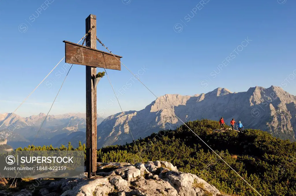 Belgian Cross, summit cross on Mt Steinplatte, female hikers, border region between Waidring, Tyrol, Austria and Reit im Winkl, Chiemgau region, Bavar...
