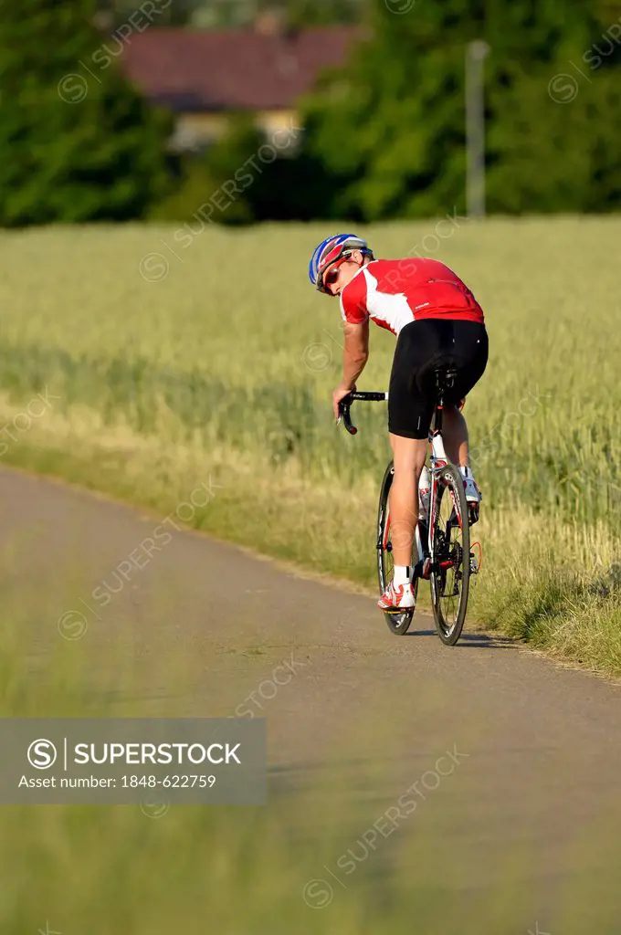 Racing cyclist looking backwards while riding a bicycle, Waiblingen, Baden-Wuerttemberg, Germany, Europe, PublicGround