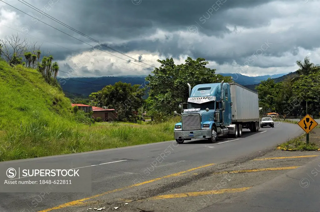 Road, large truck and storm clouds in front of San Jose, Alajuela Province, Costa Rica, Central America