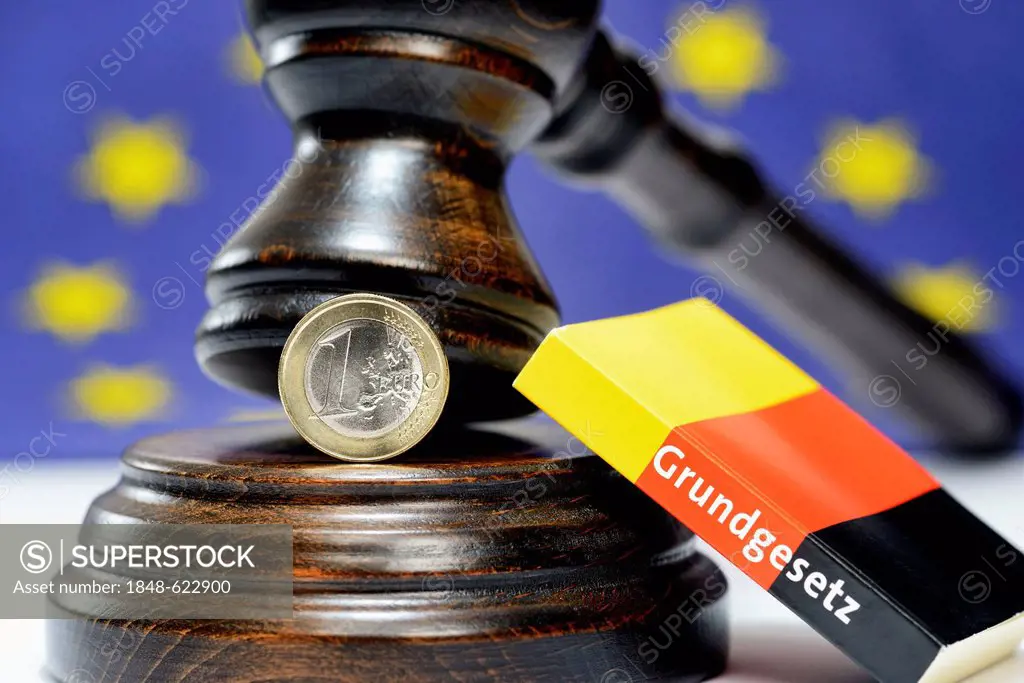 An one-euro coin, a judge's gavel and a German constitution, symbolic image for the German Federal Constitutional Court deciding on the European Stabi...