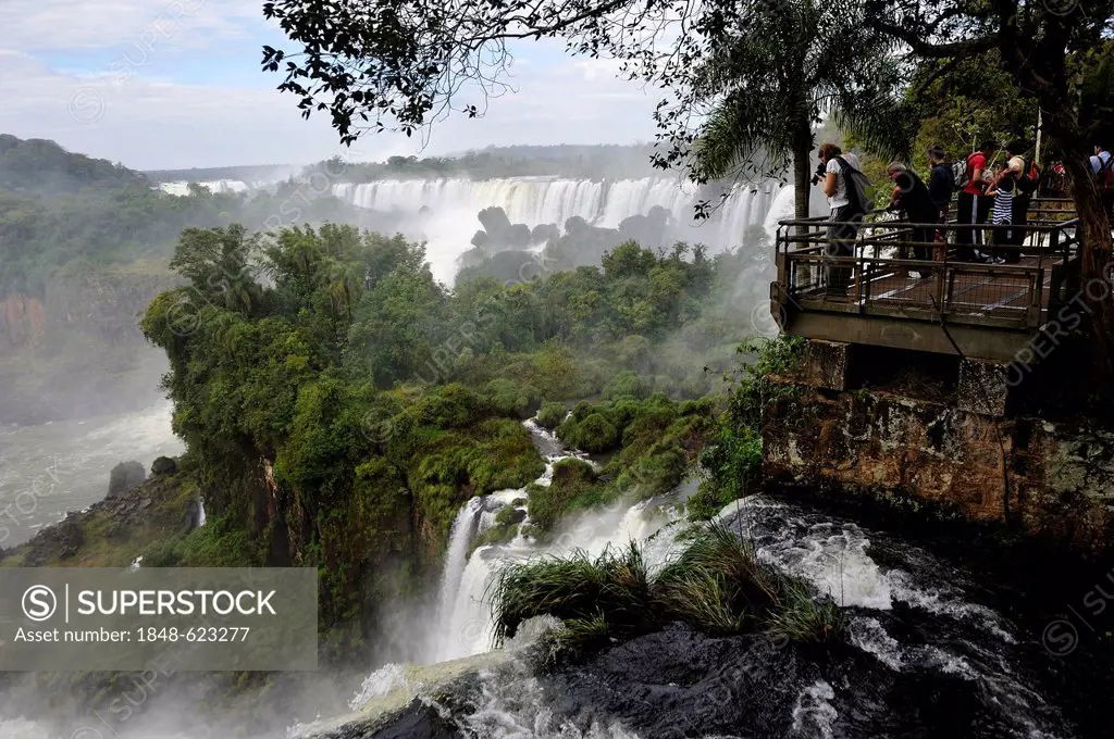 Tourists on a walkway, Iguazu or Iguacu Falls, UNESCO World Heritage Site, at the border of Brazil and Argentina, landscape of the Argentine side, Sou...