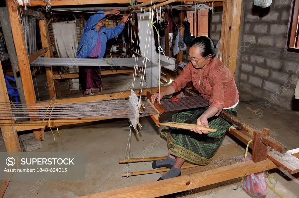 Weaver working on a hand loom in a silk factory near the town of Phansavan, Laos, Southeast Asia, Asia