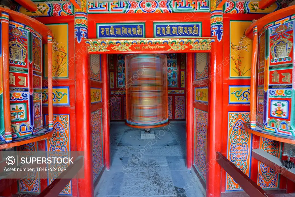 Tibetan Buddhism, a wooden prayer mill painted with symbols of Buddhism, rotating cylinder, arcade, Kora at the Labrang Monastery, Xiahe, Gansu, forme...