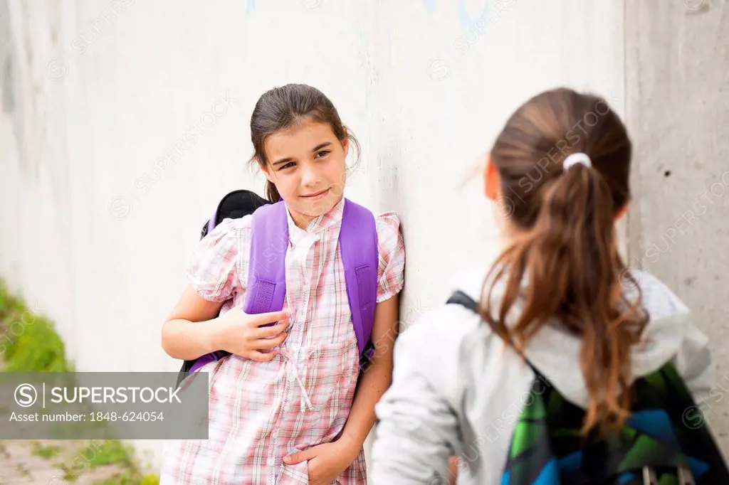 Two girls talking to each other on their way to school