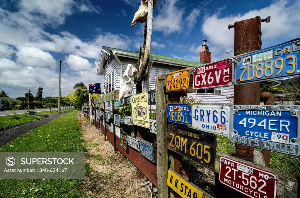 Many U.S. license plates and skulls on a wooden fence, South Island, New Zealand