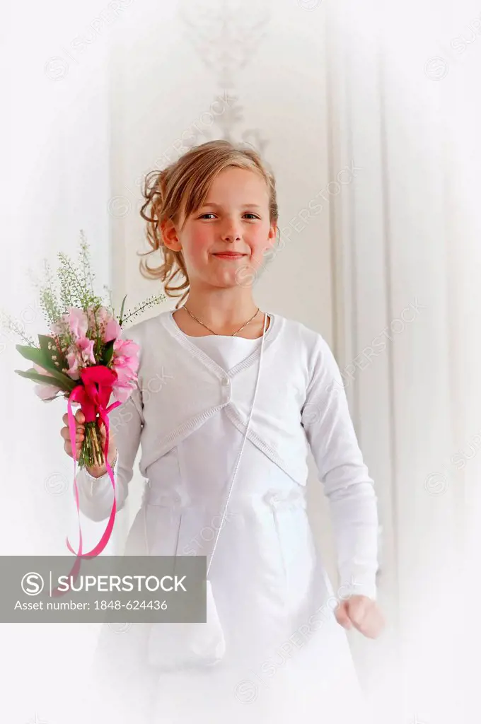 Girl, 9 years, in a white First Communion dress holding flowers, Muensterland region, North Rhine-Westphalia, Germany, Europe