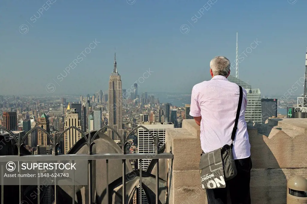 Man taking in the view from the observation deck Top of the Rock at the Rockefeller Center towards downtown Manhattan, New York City, USA, North Ameri...