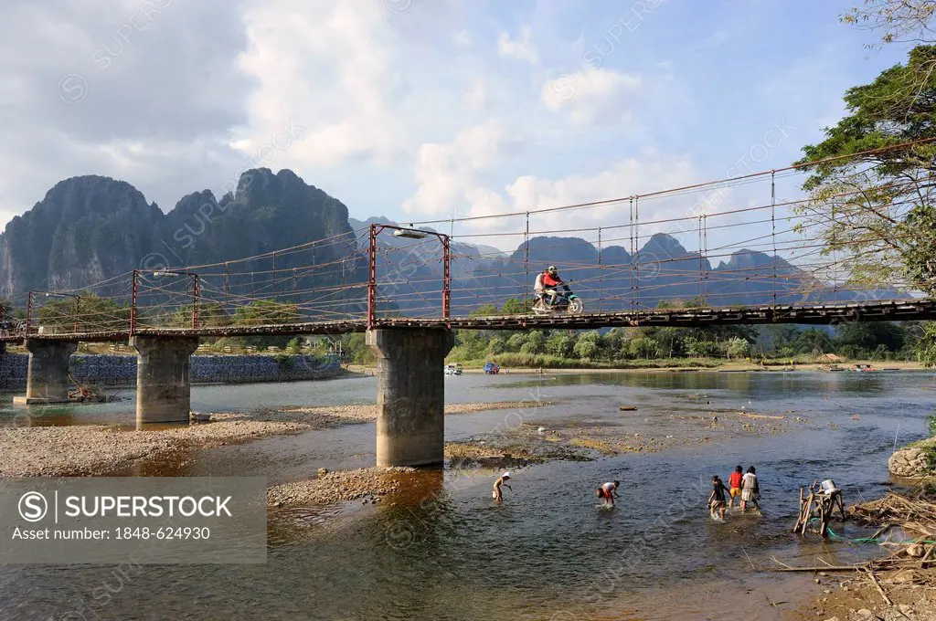 Bridge across the Nam Song river, karst mountain range at the back, Vang Vieng, Laos, Southeast Asia