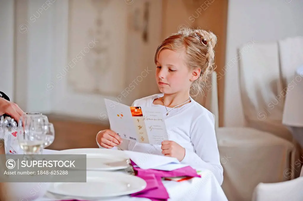 Girl, 9 years, with greeting card on her First Communion day, Muensterland region, North Rhine-Westphalia, Germany, Europe